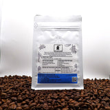 Coffee packaging with a label on a bed of coffee beans signature blend